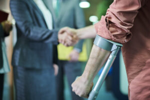 a man in crutches shaking hands with another man