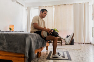 Mid adult man putting prosthetic leg at home representing injured worker recovery