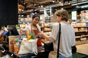 Latin American woman buying groceries at the supermarket and making a contactless payment