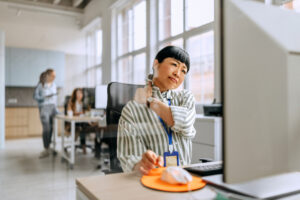 Businesswoman having neck ache due to work poor ergonomic and bad posture