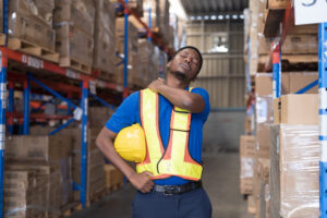 African American male worker at warehouse. Warehouse accident concept. Male warehouse worker accident at work during working in warehouse. Worker have sick while working
