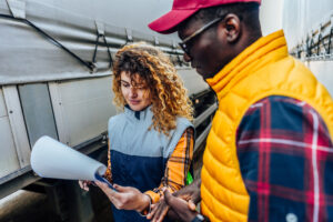 Woman inspecting the documentation of truck driver before ride
