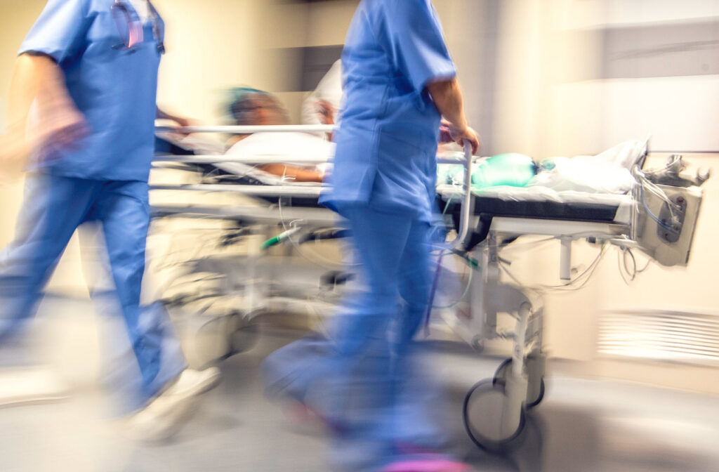 doctors rush patient on hospital bed to ICU